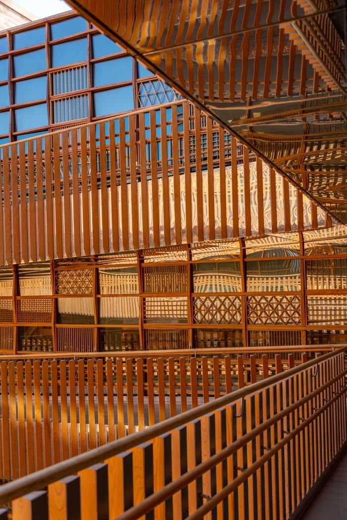 A visually striking wooden interior showcasing intricate railing design and geometric patterns.